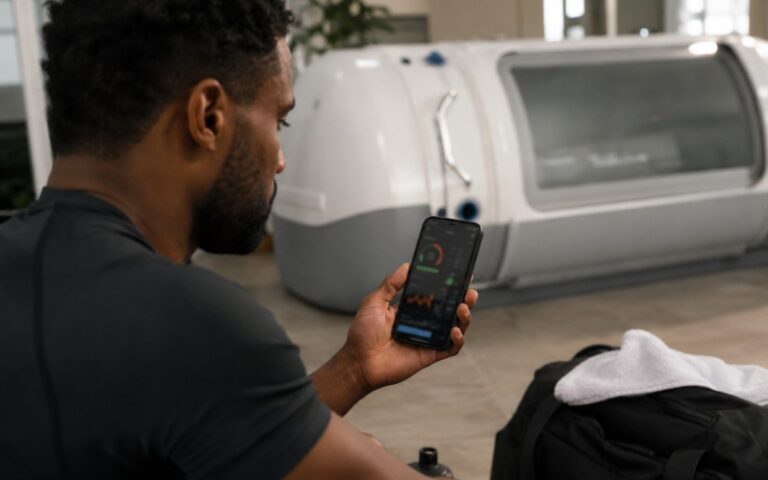 Athlete checking recovery data near chamber